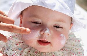 baby with sunhat and suncream